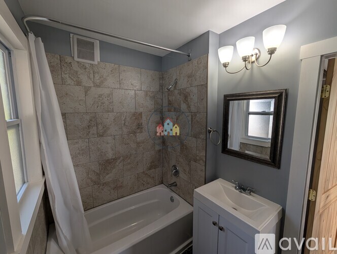 A bathroom with a tub, sink, and mirror.