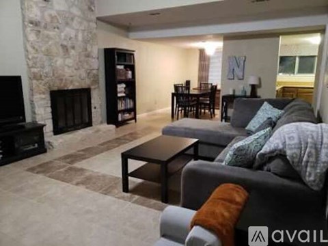 A living room with a grey couch and a fireplace.