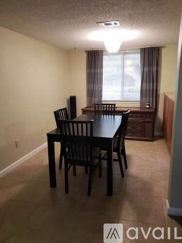 A dining room with a table and chairs.