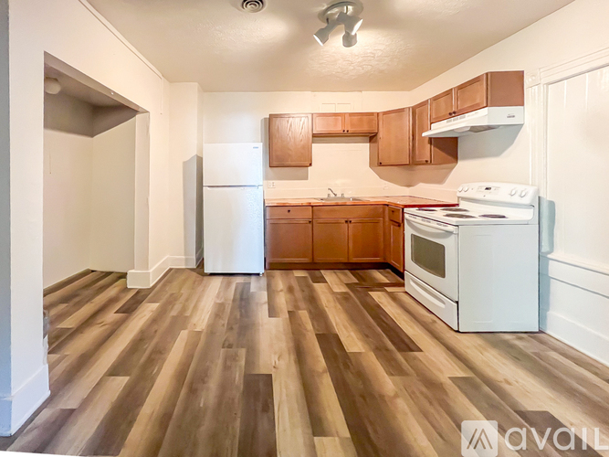 A kitchen with wooden floors and white appliances.