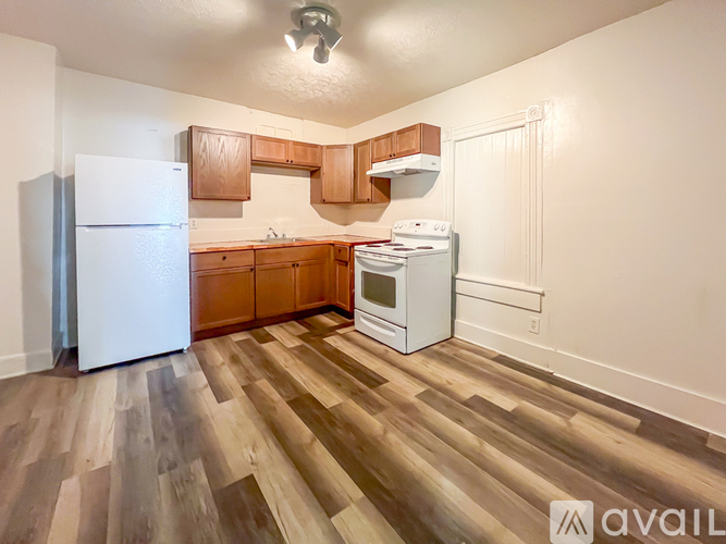 A kitchen with wooden floors and white appliances.