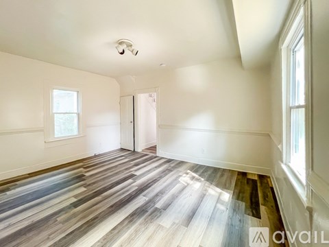 A room with a wooden floor and a ceiling fan.