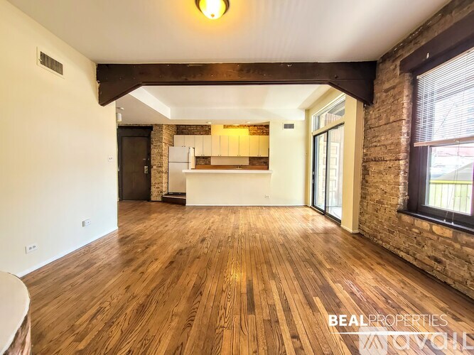 A room with wooden floors and a brick wall.