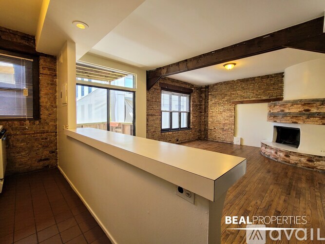 A room with a brick wall and a fireplace.