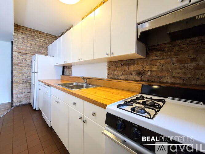 A kitchen with white cabinets and a white gas stove.