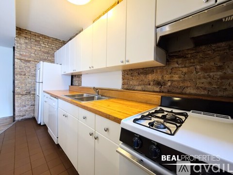 A kitchen with white cabinets and a white gas stove.