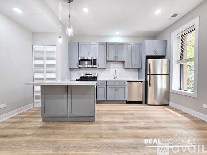 A modern kitchen with a center island and stainless steel appliances.