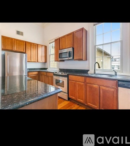 A kitchen with wooden cabinets and a stainless steel refrigerator.