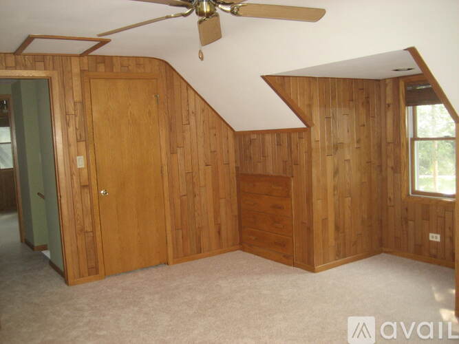 A room with wooden walls and a ceiling fan.