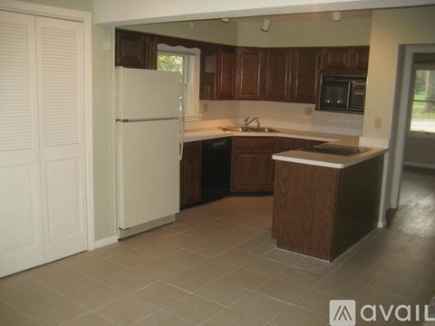 A kitchen with brown cabinets and a white refrigerator.
