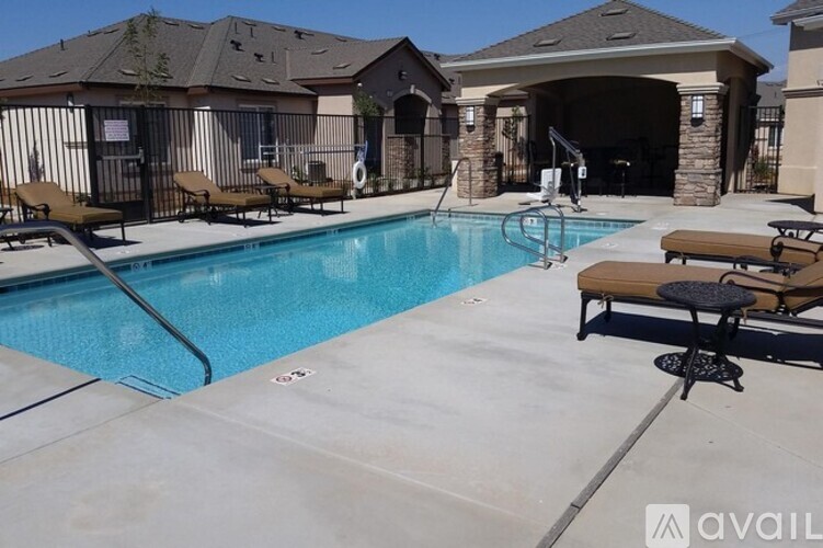 A pool with a slide and sun loungers.