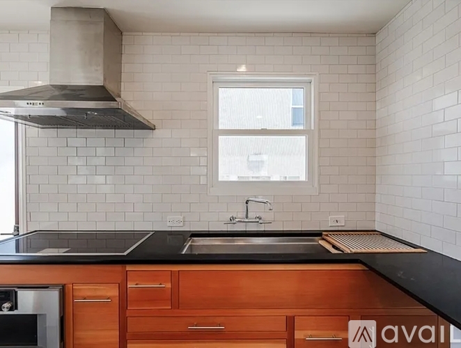 A kitchen with wooden cabinets and a black countertop.