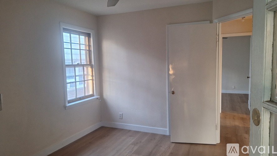 A room with a window and a door is available for rent.