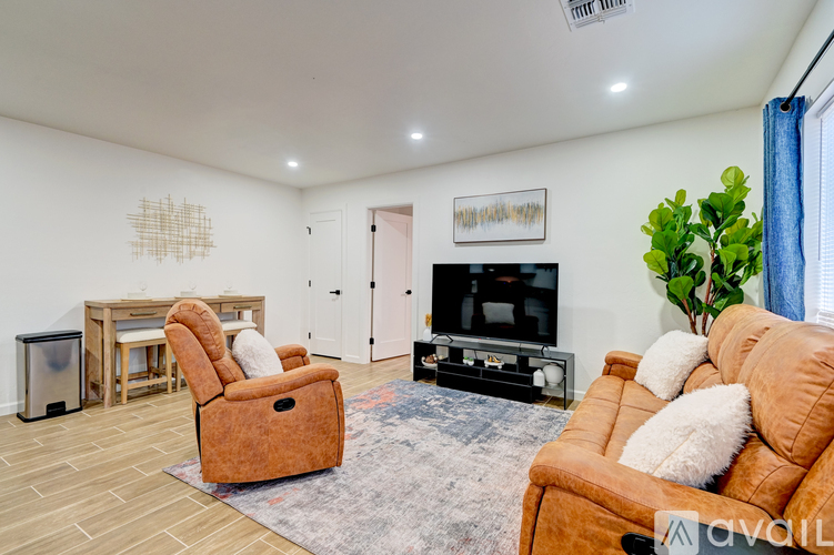 A living room with a brown leather couch and a television.