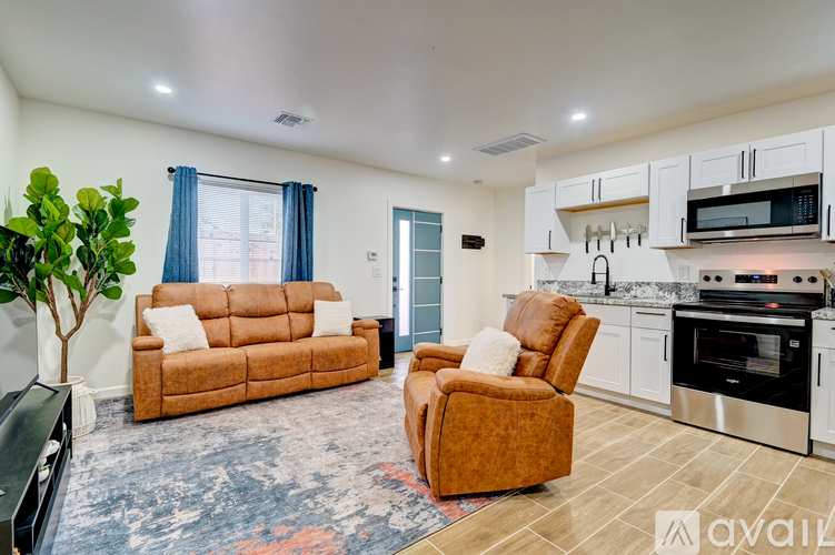 A living room with a brown couch and a brown chair.