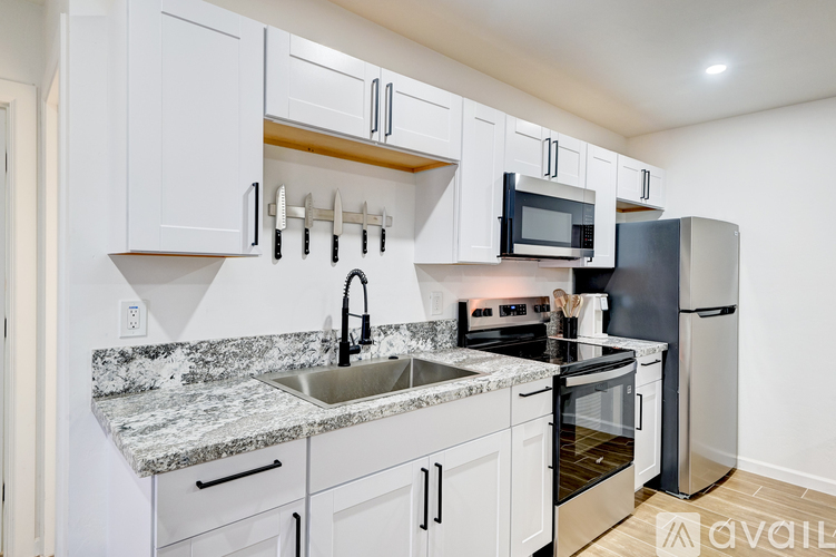 A kitchen with white cabinets and a granite countertop.