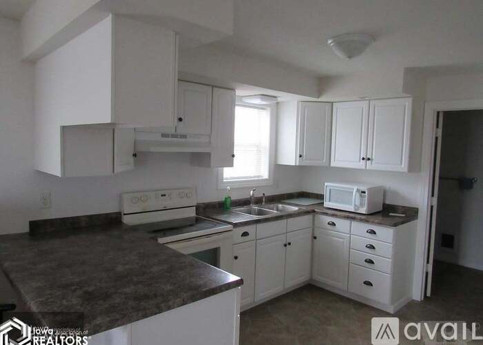 A kitchen with white cabinets and a granite countertop.