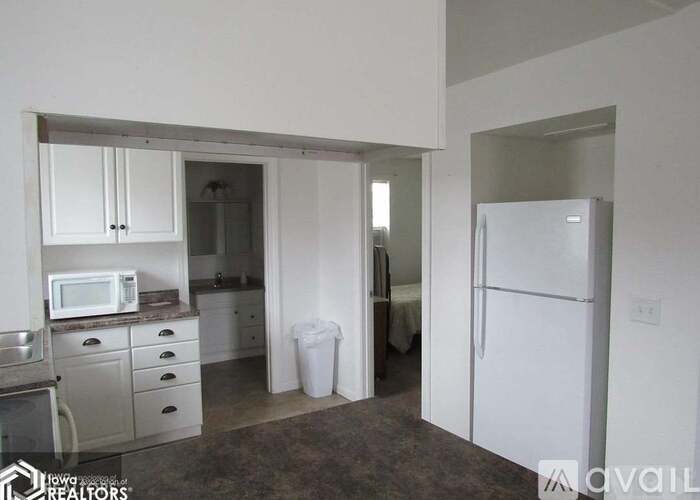 A kitchen with a white fridge and a microwave on the counter.