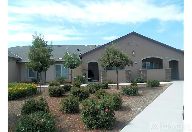 A building with a grey roof and a white wall with a window and a door.