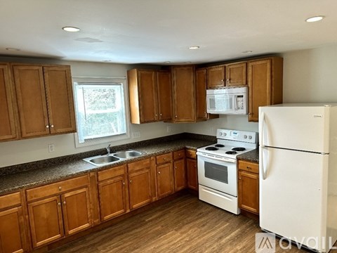 A kitchen with wooden cabinets and white appliances.