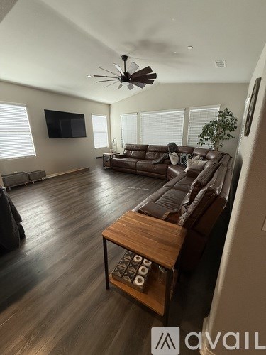 A living room with a brown leather couch and a wooden coffee table.