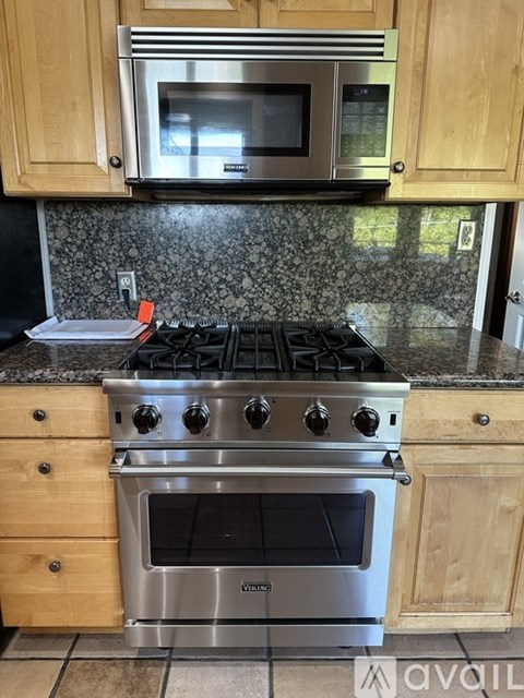 A kitchen with a stove top oven and microwave above it.
