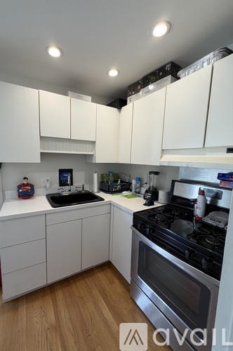 A kitchen with white cabinets and a black stove top.