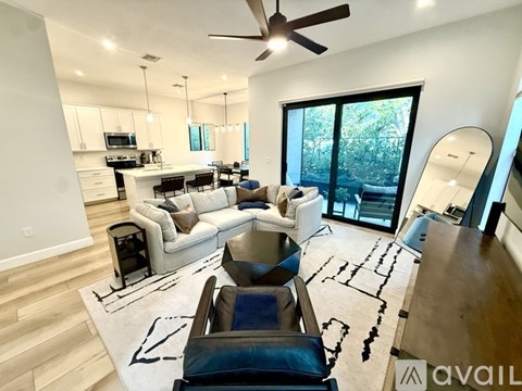 A modern living room with a white sofa and a black leather chair.
