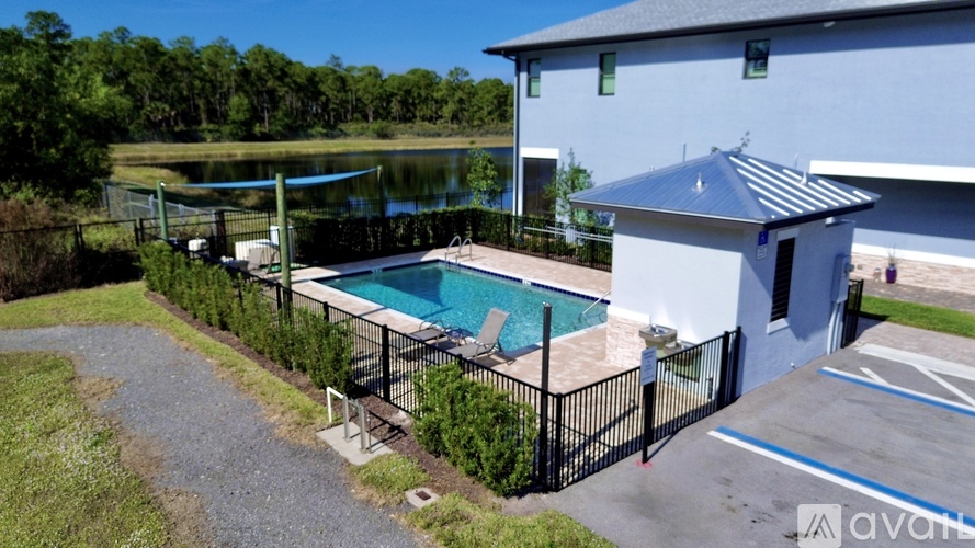 A pool and a house with a fence around it.