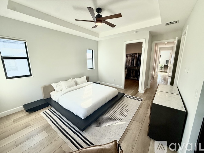 A bedroom with a large bed and a ceiling fan.
