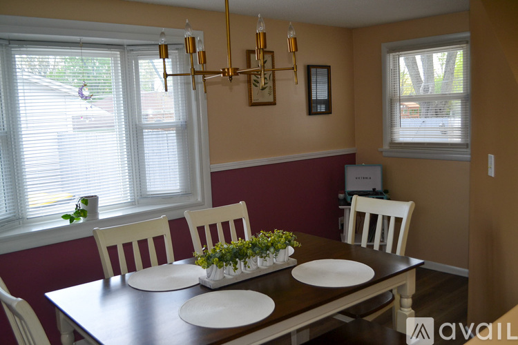A dining room with a table set for four.