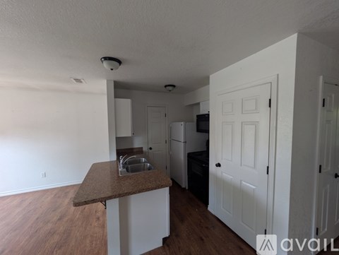 A kitchen with white cabinets and a brown countertop.
