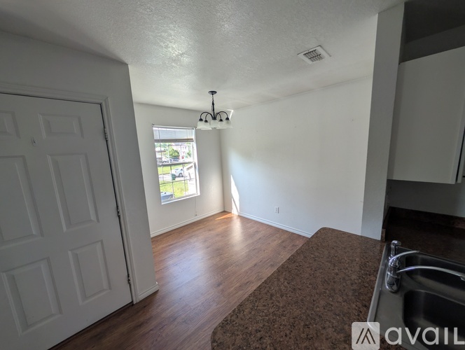 A room with a white door and a window with a view of a street.