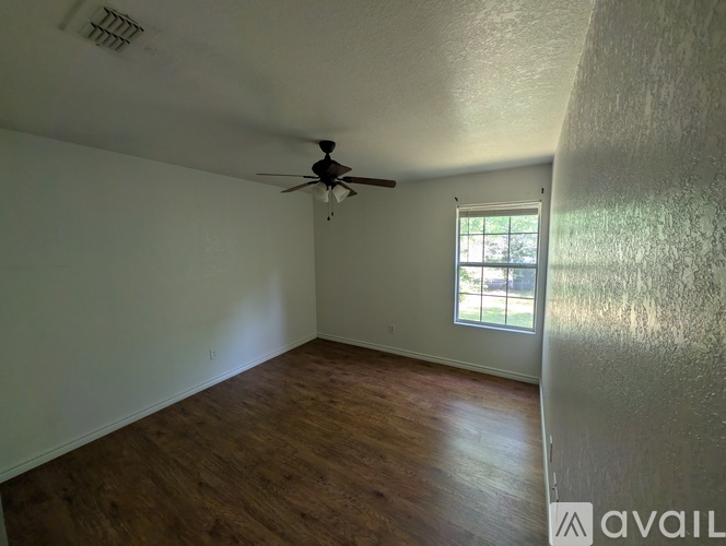 A room with a ceiling fan and a window.