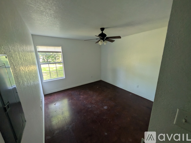 A room with a ceiling fan and a window.