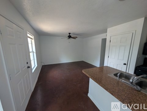 A kitchen with a brown counter top and a ceiling fan.