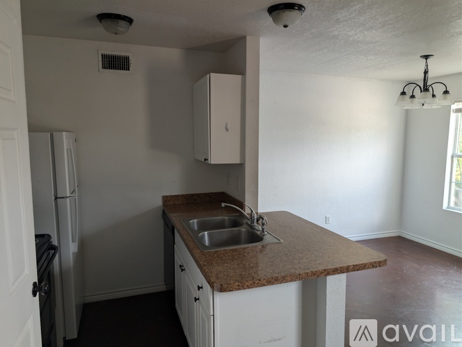 A kitchen with a sink and a refrigerator.
