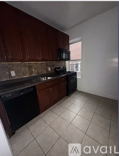 A kitchen with brown cabinets and a black oven.
