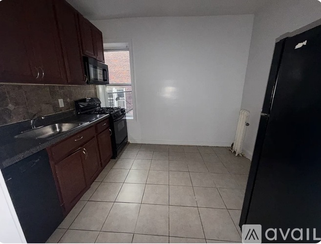 A kitchen with dark brown cabinets and black appliances.