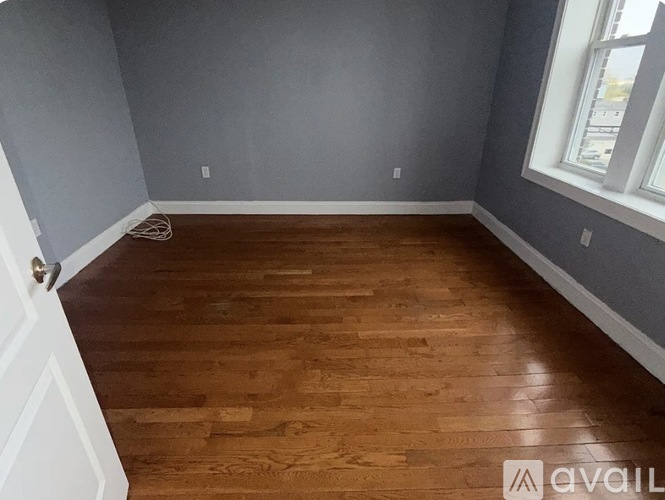 A room with wooden flooring and a white door.