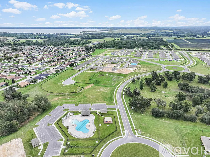A bird's eye view of a residential area with a swimming pool and a playground.