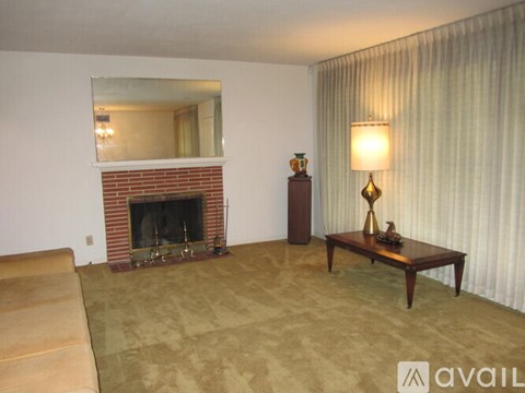 A living room with a fireplace and a mirror above it.