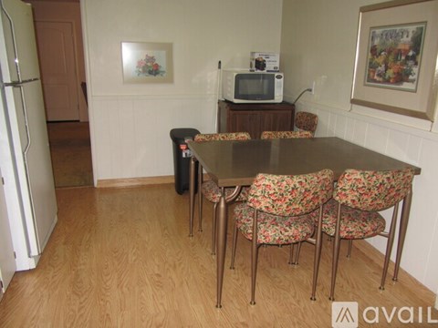 A kitchen with a table and chairs.