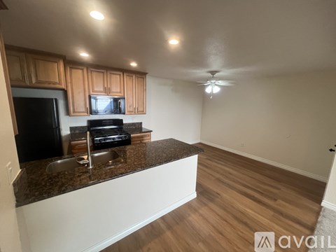 A kitchen with wooden cabinets and a granite countertop.