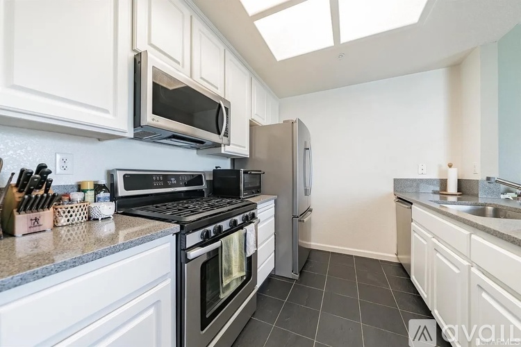 A kitchen with white cabinets and black appliances.