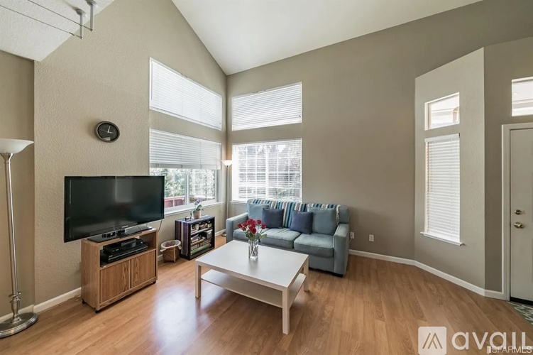 A living room with a television, a couch, and a coffee table.
