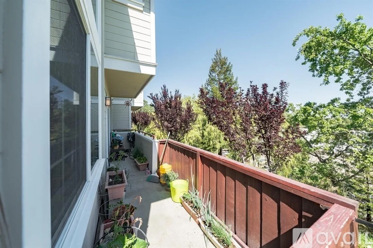 A balcony with a view of trees and a clear sky.