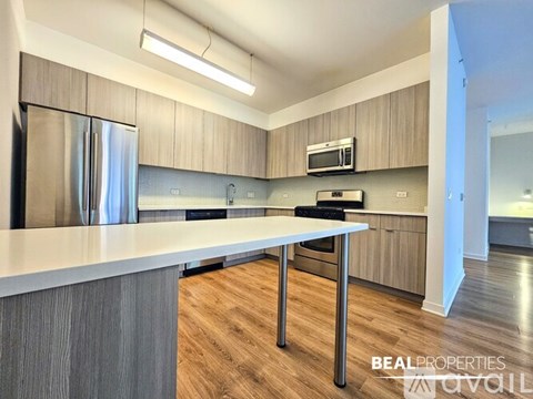 A modern kitchen with a stainless steel refrigerator and a white countertop.
