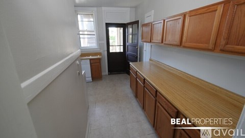 A kitchen with wooden cabinets and a black refrigerator.