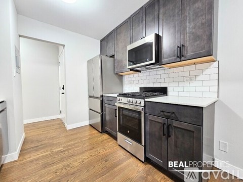 A kitchen with black cabinets and a stove top oven.